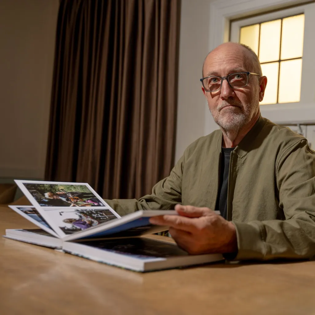 Bill Delzell holds a photobook from his collection at the Internet Archive on Thursday.