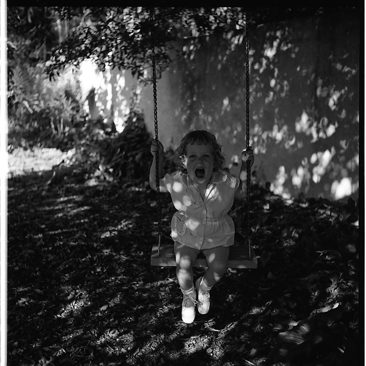 Vivian Maier, Little Girl Swinging in Shadows, Los Angeles, 1955